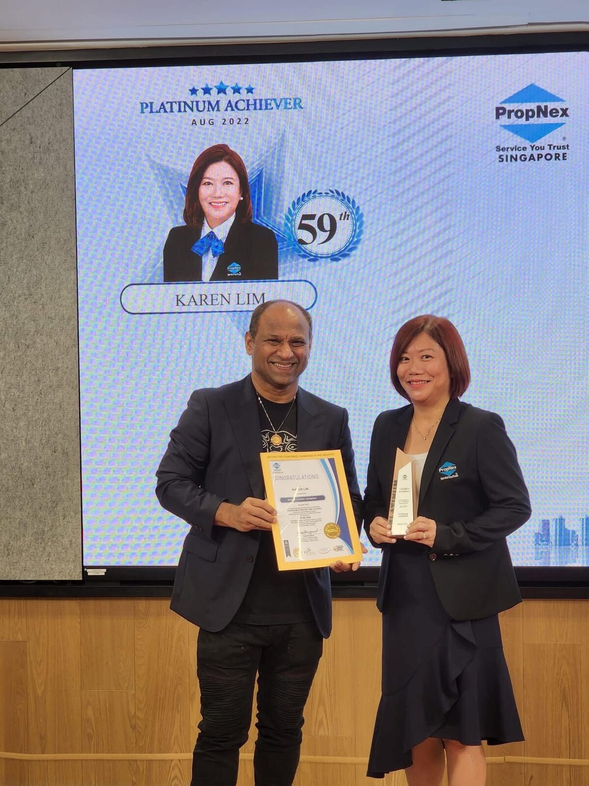 Karen Lim receiving the PropNex Platinum Achiever award for August 2022 on stage