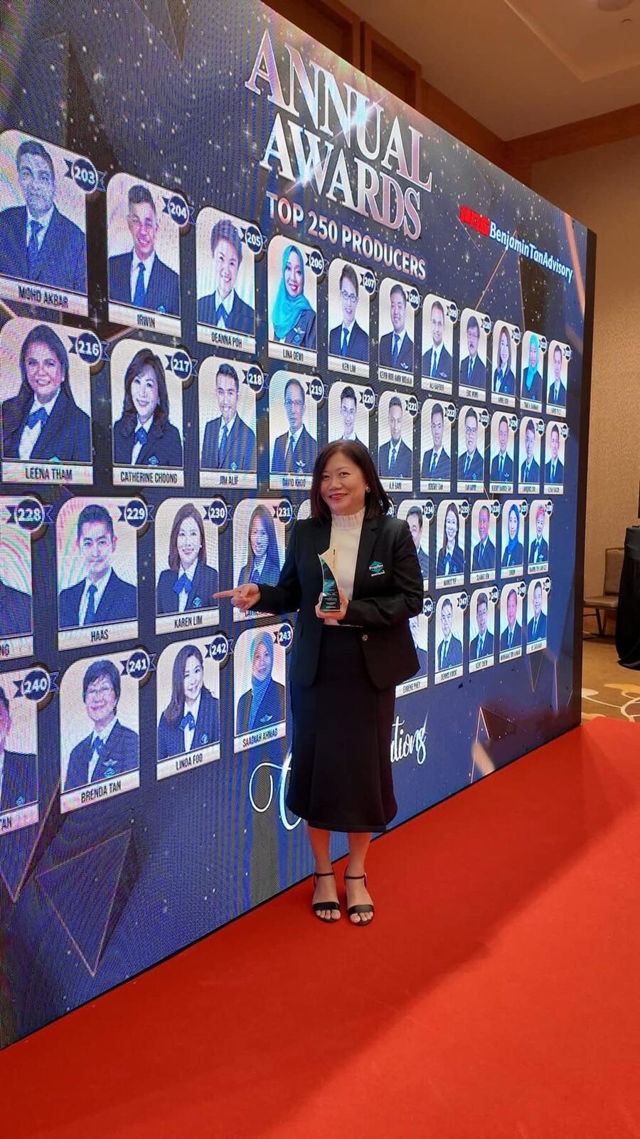 Karen Lim holding a trophy at the PropNex annual awards